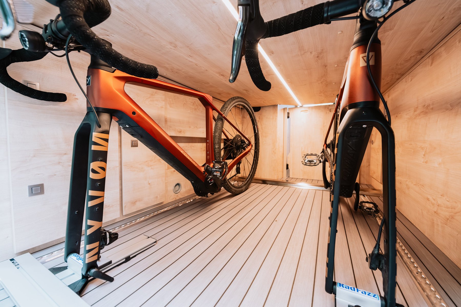 Detail Heckgarage: durchgehender Holzboden, LED-Lichtleiste und Zurrschienen für sicheren Bike-Transport