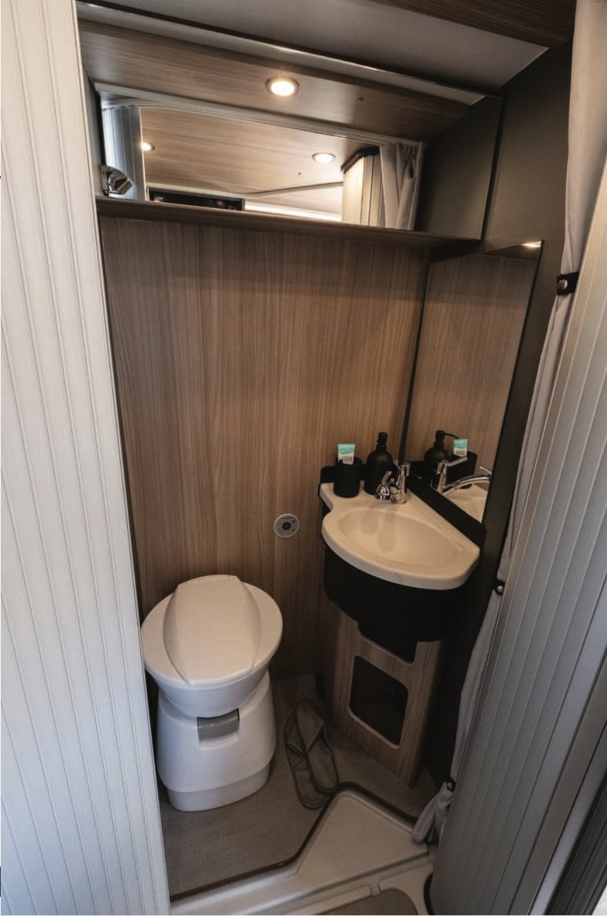 Raumbad mit Bank-WC, Waschbecken und Spiegel